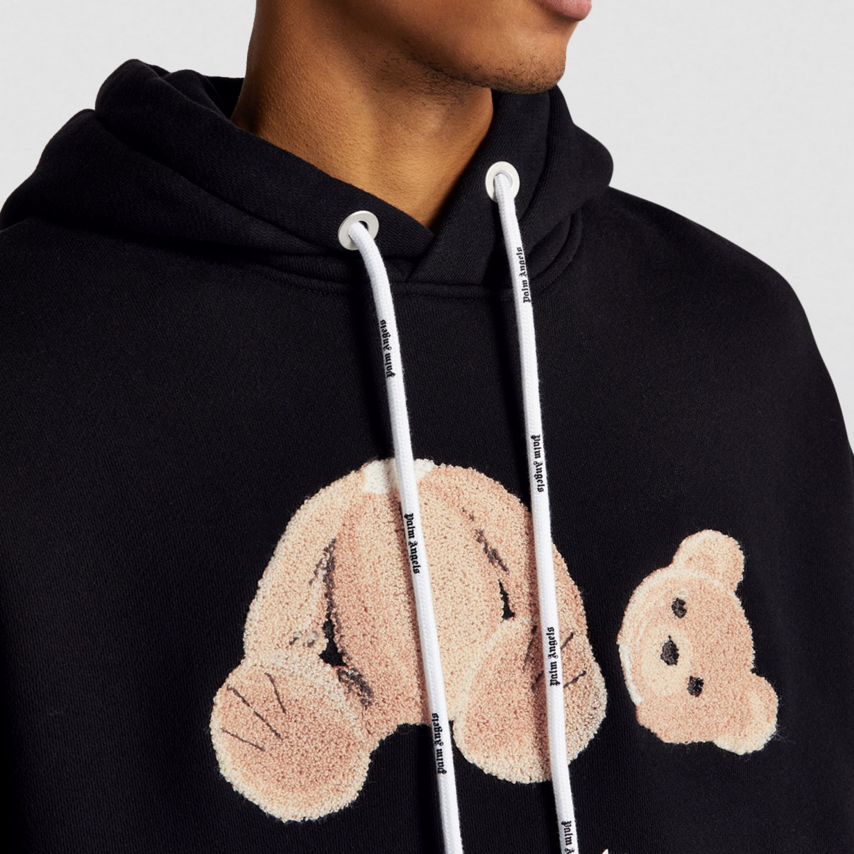 Man wearing a Fear of God winter hoodie standing outdoors in cold weather.