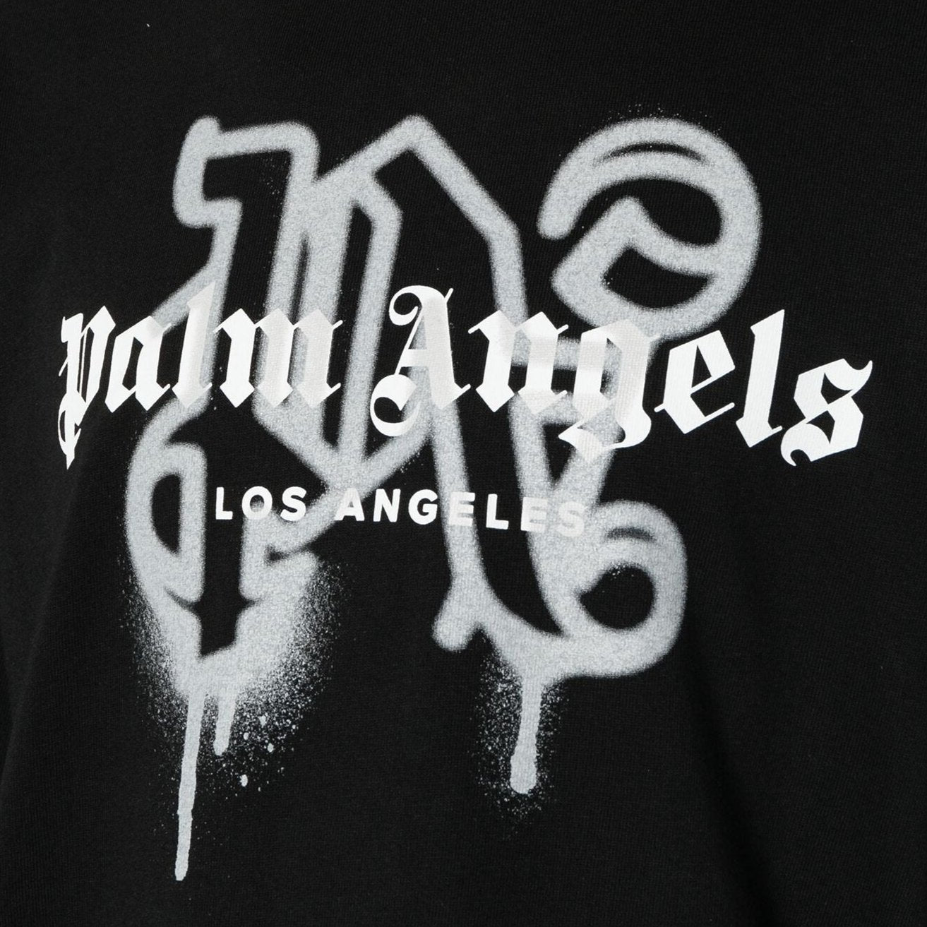 The Palm Angels Los Angeles Monogram Sprayed Logo T-Shirt is a black cotton jersey piece that showcases the iconic "Palm Angels Los Angeles" in a white Gothic-style font. The lettering features a spray-paint effect with subtle drips, emphasizing an edgy Los Angeles monogram vibe.