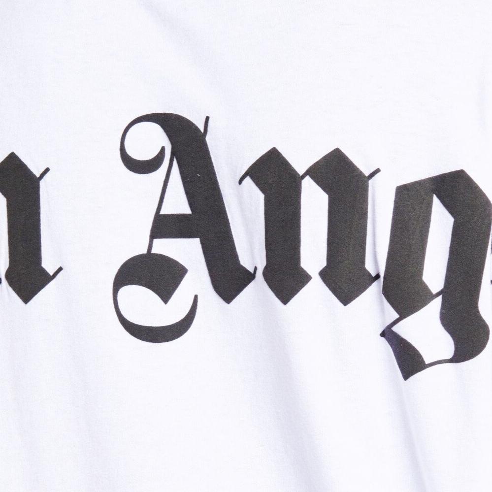 Close-up of the Palm Angels Oversize Neck Logo T-Shirt in white fabric, featuring bold, black gothic-style text that partially spells out a word, suggesting an edgy logo print by Palm Angels.