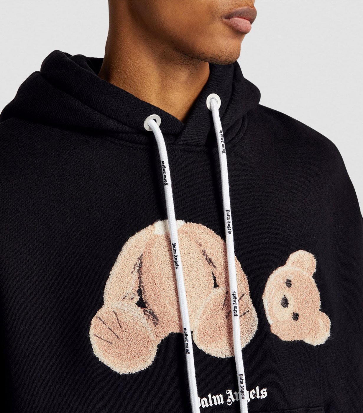 Man wearing a Fear of God winter hoodie standing outdoors in cold weather.