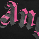 Detailed view of the Palm Angels logo in stylized pink text on a black background. The ornate, Gothic font with bold strokes features overlapping shades of pink and gray, as seen on the Palm Angels Oversize Double Printed Neck Logo T-Shirt in Black/Pink.