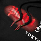 Here's a closer look at the Palm Angels Tokyo Sprayed Logo Hoodie, made from high-quality heavyweight cotton. This black hoodie, complete with matching black drawstrings and features a striking red and white graphic design. The stylized "U" and "H" letters are designed with a dripping effect that captures the essence of Palm Angels’ distinctive style.
