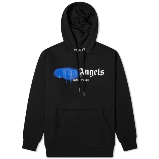 Introducing the Palm Angels New York Sprayed Logo Hoodie: a black hoodie featuring a large front pocket and a drawstring hood. The design showcases "Angels New York," with the first part creatively obscured by a graffiti-style blue paint dripping effect, delivering an edgy sprayed logo look.