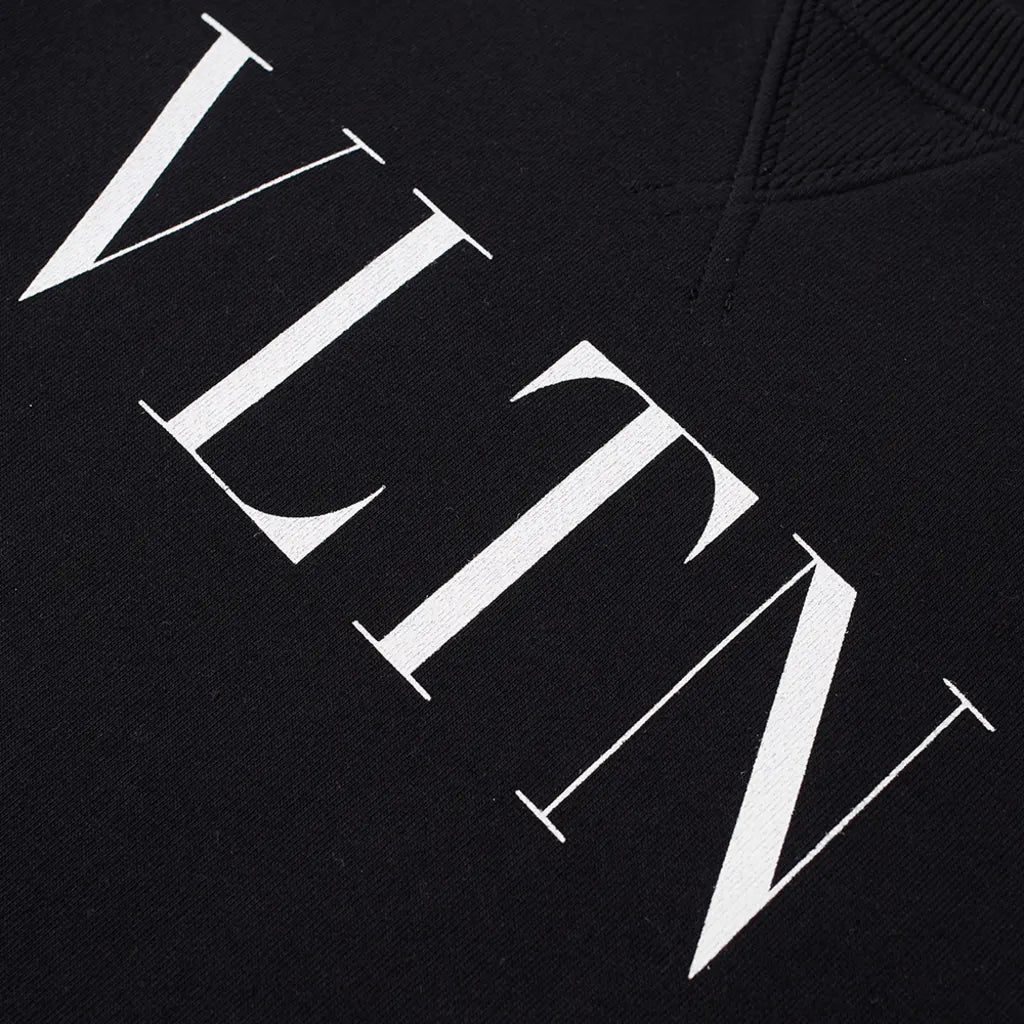 A detailed view of the Valentino VLTN Logo Sweatshirt showcases bold white "VLTN" lettering in a contemporary serif font. The textured material emphasizes the brand's luxurious VLTN design, embodying the exquisite craftsmanship that is characteristic of Italian-made products.