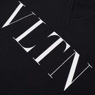 A detailed view of the Valentino VLTN Logo Sweatshirt showcases bold white "VLTN" lettering in a contemporary serif font. The textured material emphasizes the brand's luxurious VLTN design, embodying the exquisite craftsmanship that is characteristic of Italian-made products.
