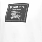 The Burberry Roundwood Logo T-Shirt in white features the premium cotton fabric and is adorned with an embroidered Burberry logo, displaying "BURBERRY LONDON ENGLAND" above an intricate depiction of a medieval knight on horseback carrying a lance with a flag.