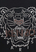 The Kenzo Oversize Embroidered Tiger T-Shirt in Black/Brown showcases a black fabric with an embroidered tiger face crafted with white and brown threads. The bold "KENZO" in brown and "PARIS" in crisp white complete the design, making it a striking blend of artistry and fashion.