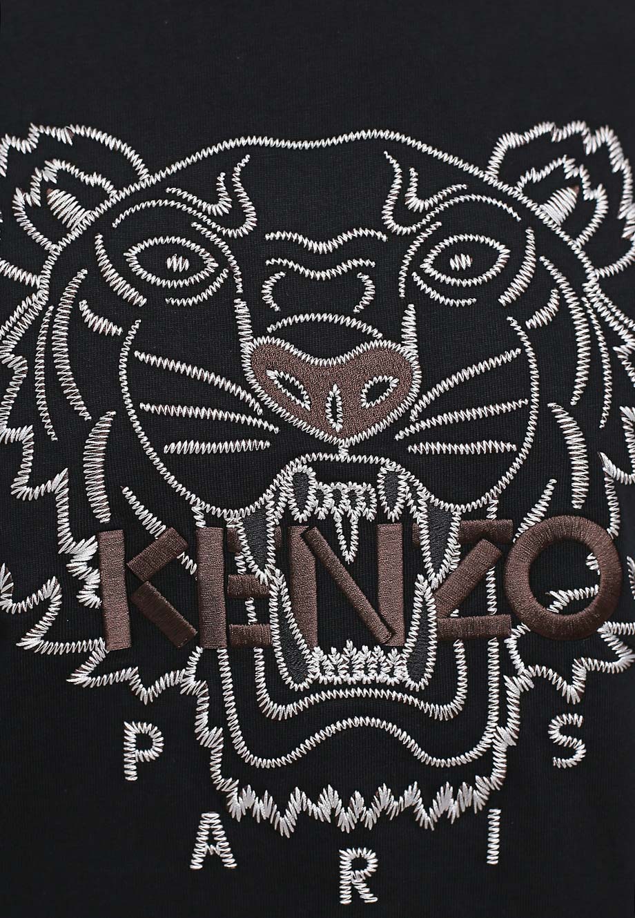 The Kenzo Oversize Embroidered Tiger T-Shirt in Black/Brown showcases a black fabric with an embroidered tiger face crafted with white and brown threads. The bold "KENZO" in brown and "PARIS" in crisp white complete the design, making it a striking blend of artistry and fashion.