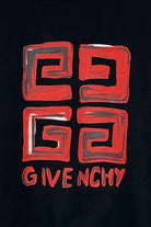 A striking black backdrop highlights the Givenchy Paris 4G Logo T-Shirt, featuring a bold and abstract red emblem formed by four interconnected squares. Below, "Givenchy" is elegantly inscribed in stylized red lettering. This design is inspired by a slim fit aesthetic and pairs seamlessly with soft cotton clothing.
