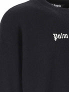 Close-up of the Palm Angels Classic Wool Logo Sweater, showcasing "Palm" in white Gothic lettering on a black background. Crafted from merino wool, the texture suggests a soft, luxurious material. The rest of this sweater by Palm Angels is plain, highlighting its understated elegance.