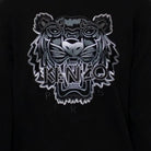 The Kenzo Gradient Tiger Embroidered Sweatshirt showcases Parisian flair with its detailed silver and gray tiger head embroidery. The bold "KENZO" branding is prominently featured across the face, accompanied by the partially visible "PARIS" beneath.