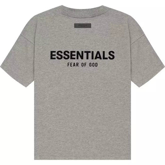 The Fear of God ESSENTIALS SS22 T-Shirt in Dark Oatmeal from the brand Fear of God ESSENTIALS captures the style's essence with "ESSENTIALS" prominently displayed in bold black letters and "FEAR OF GOD" subtly beneath.