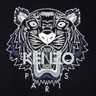 The Kenzo Classic Tiger T-Shirt features an illustrated tiger face in black, white, and blue on a dark background. The word "KENZO" is displayed across the tiger's mouth with "PARIS" underneath, creating a bold and graphic design that stands out beautifully on this premium cotton black tee by Kenzo.