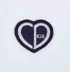 Introducing the Dior "CD" Heart Patch T-Shirt, this remarkable piece features a heart-shaped logo with a striking black and white split design. The letters "C" grace the left side, while "D" adorns the right, inspired by Dior's iconic heart patch for an elegant touch to any cotton jersey ensemble.