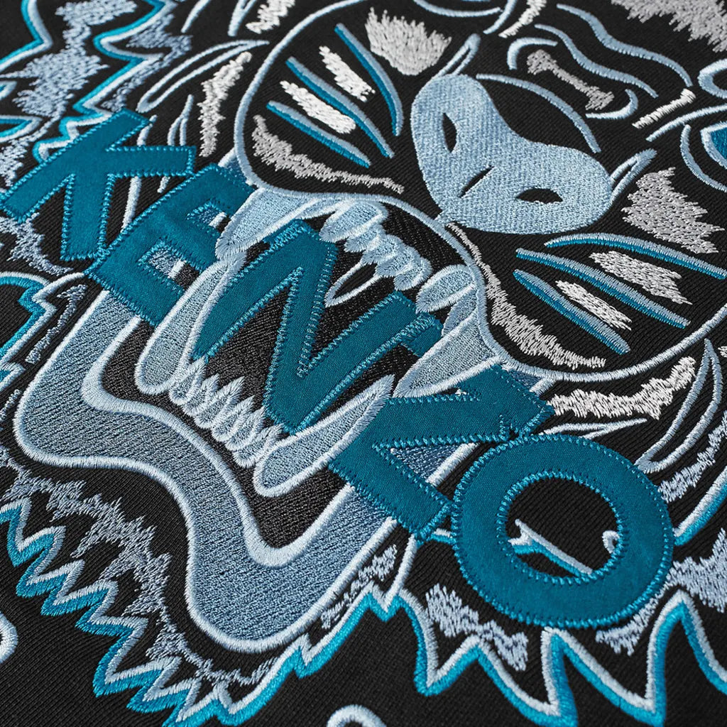 A close-up of the Kenzo Classic Tiger Embroidered Sweatshirt reveals the intricate details of its embroidered tiger emblem, reminiscent of Parisian style.