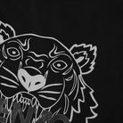 A stylized graphic of a tiger's fierce visage, outlined in white on a black background with bold lines and sharp details, is prominently featured on the Kenzo Festive Classic Tiger Print T-Shirt. The word "KENZO" is partially visible beneath the illustration, blending art and style seamlessly in this festive tee.