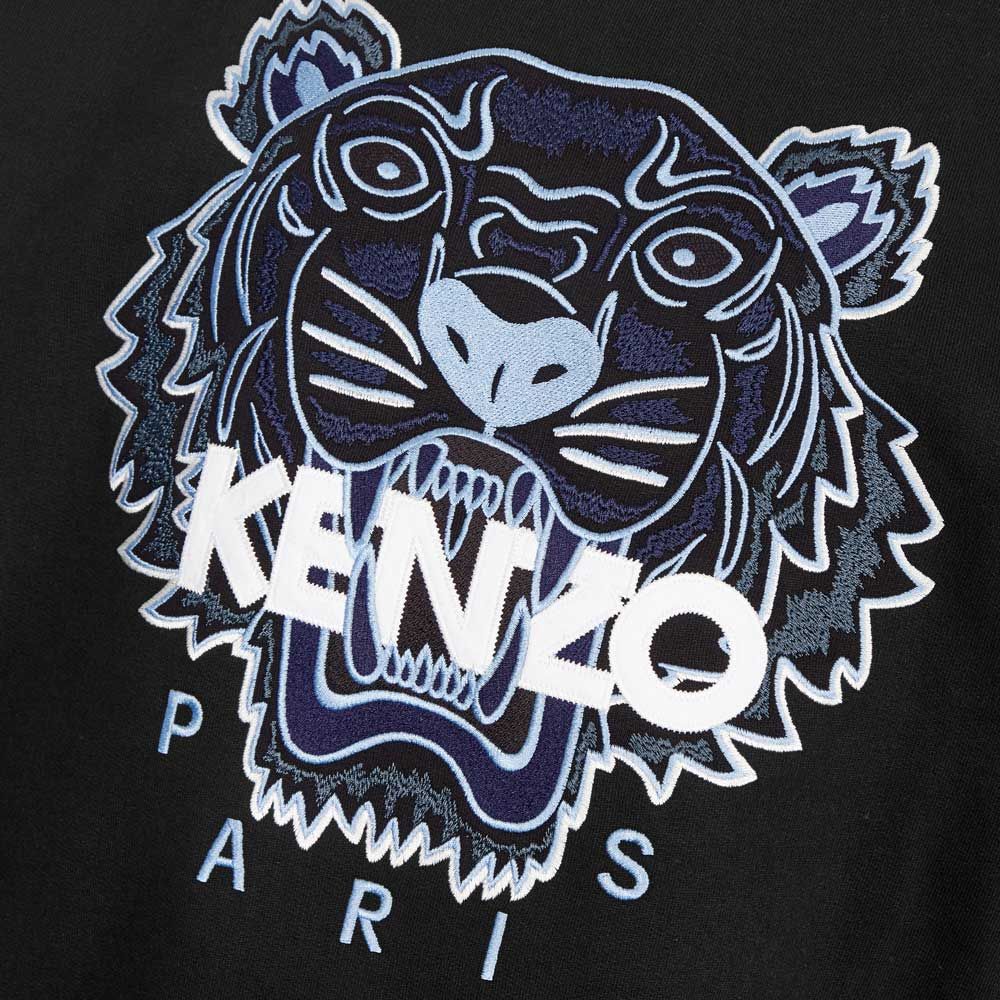 The Kenzo Classic Tiger Embroidered Sweatshirt showcases a blue and white embroidered tiger emblem, featuring a roaring head with "KENZO" emblazoned across it and "PARIS" beneath, all set against a black background to exude Parisian style.