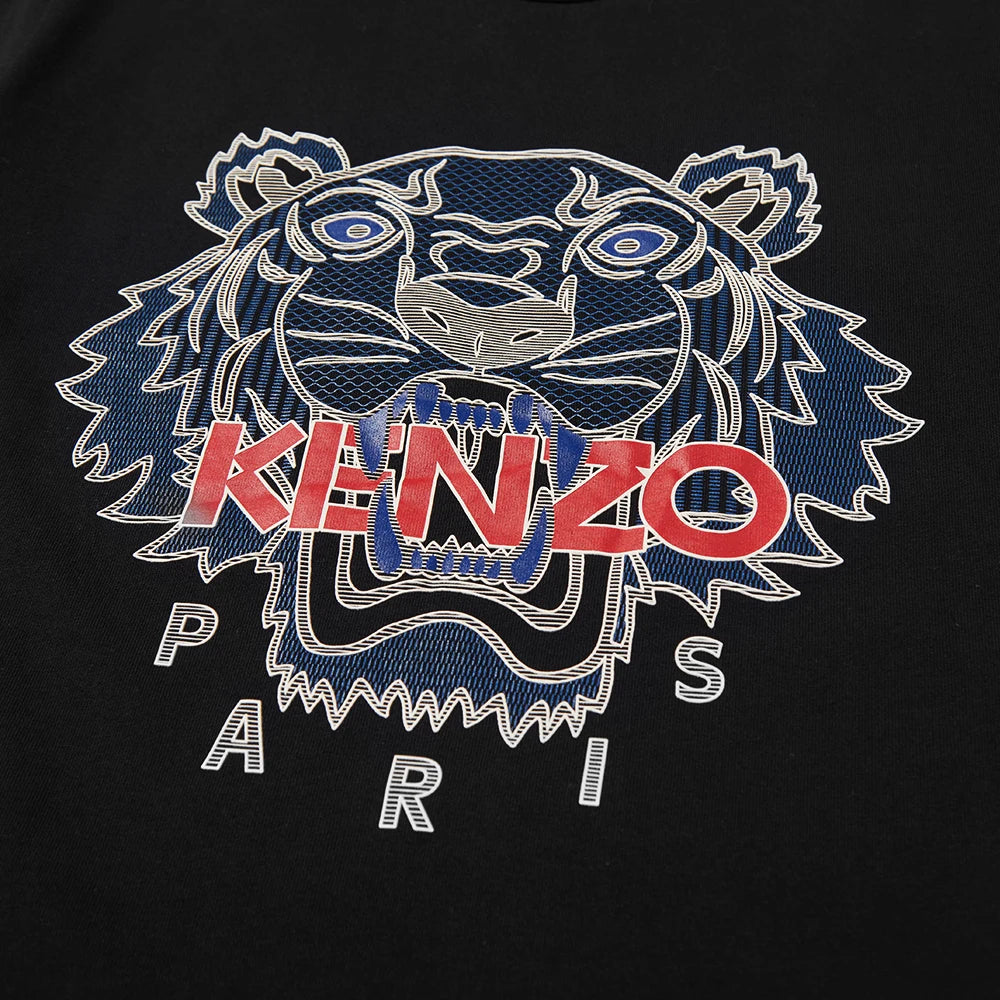 The Averlo Kenzo Black Silicone Scuba Tiger T-Shirt showcases a slim fit cotton crewneck adorned with a stylized tiger face graphic. Blue and white lines, an open mouth, and bold red letters spell "KENZO" across it, while the word "PARIS" is elegantly displayed below in white against the black background.